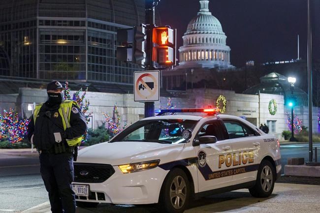 A U.S. Capitol Police officer stands watch on Independence Avenue before dawn as the House and Senate prepare to convene a joint session to count the electoral votes cast in November's election, on Capitol Hill in Washington, Wednesday, Jan. 6, 2021. (AP Photo/J. Scott Applewhite)