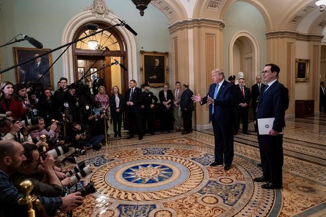 President Donald Trump, joined by Treasury Secretary Steven Mnuchin, right, speaks to reporters after meeting with Republican senators, on Capitol Hill in Washington, Tuesday, March 10, 2020. Trump wants Congress to pass payroll tax relief as he looks to calm financial markets' fears over the impact of the coronavirus epidemic. (AP Photo/J. Scott Applewhite)