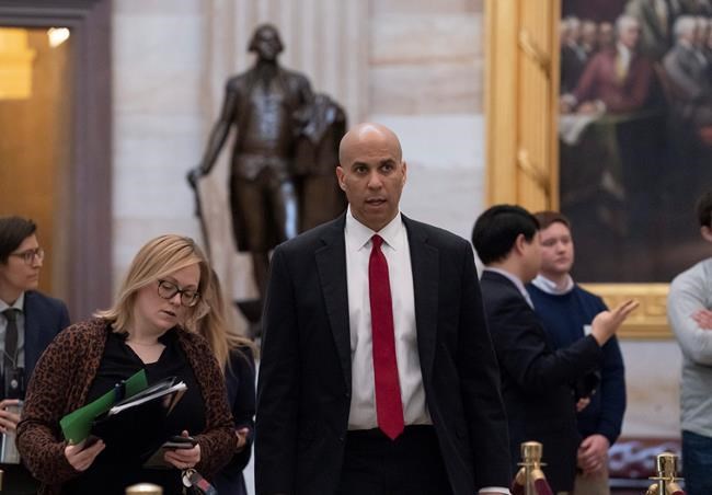 Sen. Cory Booker, D-N.J., walks to the Senate as work resumes in the impeachment trial of President Donald Trump on charges of abuse of power and obstruction of Congress, in Washington, Friday, Jan. 24, 2020. (AP Photo/J. Scott Applewhite)