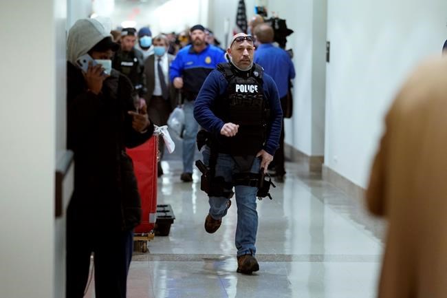 People run in the halls as protesters try to break into the House Chamber at the U.S. Capitol on Wednesday, Jan. 6, 2021, in Washington. (AP Photo/Andrew Harnik)