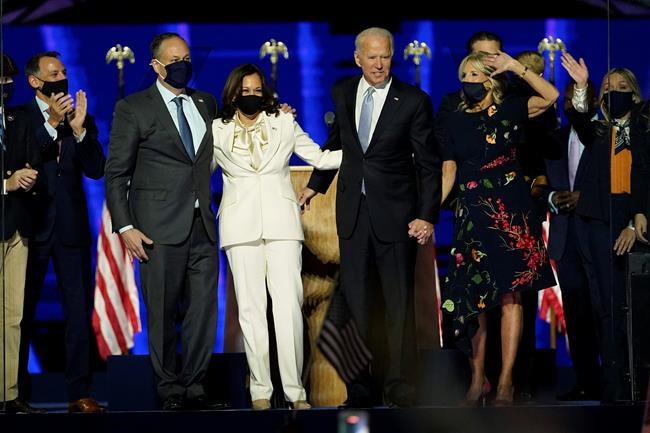 From left, Doug Emhoff, husband of Vice President-elect Kamala Harris, Harris, President-elect Joe Biden and his wife Jill Biden on stage together, Saturday, Nov. 7, 2020, in Wilmington, Del.(AP Photo/Andrew Harnik, Pool)