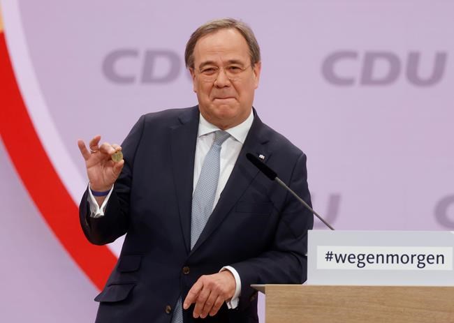 North Rhine-Westphalia's Governor and candidate as leader of the Christian Democratic Union (CDU) Armin Laschet shows a luck coin offered to him by his father as he delivers his speech on the second day of the party's 33rd congress held online because of the coronavirus pandemic, in Berlin on January 16, 2021. German Chancellor Angela Merkel’s party is choosing a new leader on Saturday, eight months before voters decide who will succeed Merkel in a national election. (Odd Andersen/Pool via AP)
