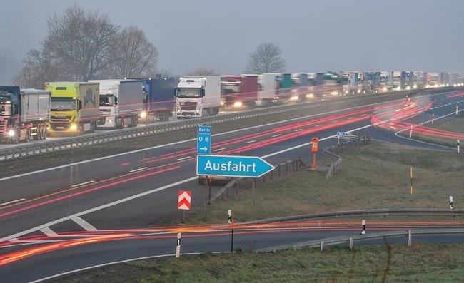Trucks are jammed in the early morning on Autobahn 12 in front of the German-Polish border crossing near Frankfurt (Oder), Germany, Wednesday, March 18, 2020. In order to make it more difficult for the corona virus to spread, Poland had reintroduced controls at the border crossings to Germany. For most people, the new coronavirus causes only mild or moderate symptoms, such as fever and cough. For some, especially older adults and people with existing health problems, it can cause more severe illness, including pneumonia. (Patrick Pleul/dpa via AP)