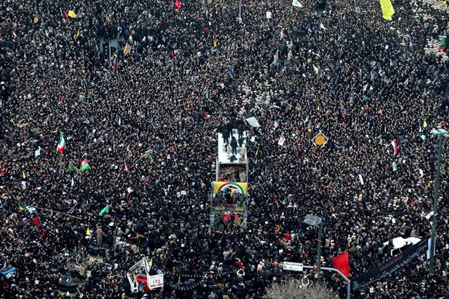 Coffins of Gen. Qassem Soleimani and his comrades who were killed in Iraq by a U.S. drone strike, are carried on a truck surrounded by mourners during a funeral procession, in the city of Mashhad, Iran, Sunday, Jan. 5, 2020. Soleimani's death Friday in Iraq further heightens tensions between Tehran and Washington after months of trading attacks and threats that put the wider Middle East on edge. (Mohammad Hossein Thaghi/Tasnim News Agency via AP)