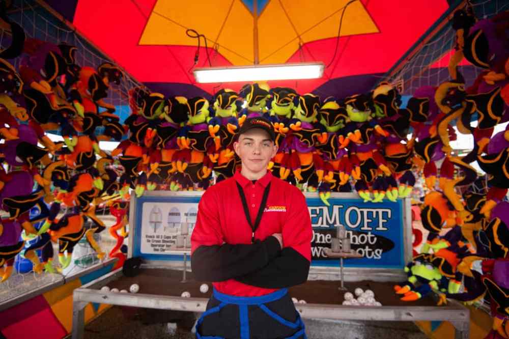 MIKE SUDOMA / Winnipeg Free Press
15-year-old Eric Bonas works the “knock ‘em off” game at the Red River Exhibition’s Autumn Fair, Friday night.