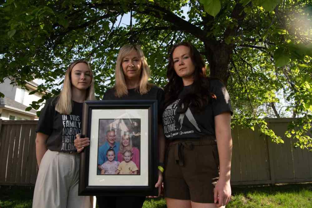 ALEX LUPUL / WINNIPEG FREE PRESS
Jo-Anne McNeil holds a family photo with her daughters Sarah and Taylor. Jo-Anne's husband Pat McNeil is weeks away from dying of brain cancer but he can only see his wife while in palliative care, not their daughters.