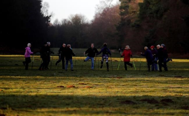 People take part in a morning activity near an entrance of Sandringham estate, Sandringham, England, early morning Monday, Jan. 13, 2020. Britain's Queen Elizabeth II is preparing for a crisis family meeting to work out a future for Prince Harry and his wife, Meghan, after their dramatic decision to walk away from royal roles. (AP Photo/Frank Augstein)