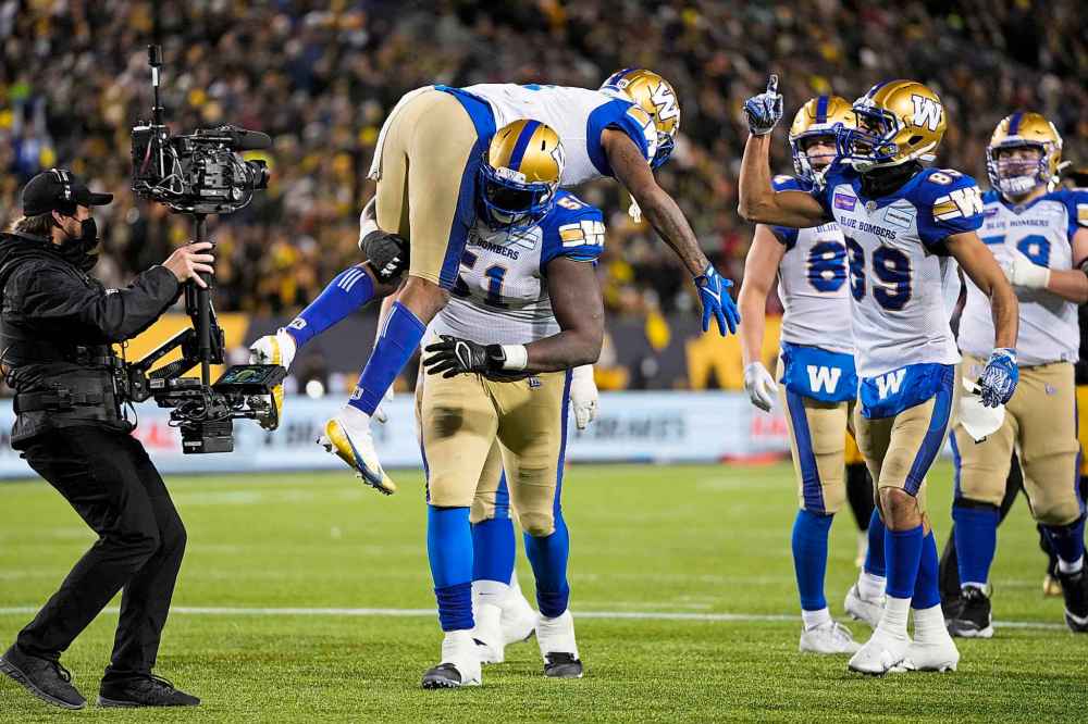 CP
Winnipeg Blue Bombers offensive lineman Jermarcus Hardrick (51) lifts up wide receiver Darvin Adams (1) after he scored a touchdown during overtime. (Nathan Denette / The Canadian Press)