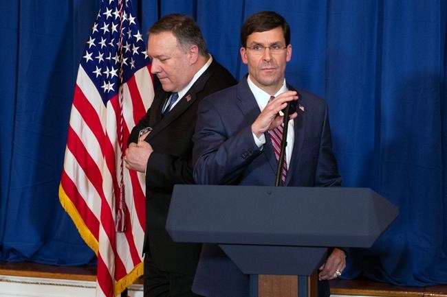 Secretary of State Mike Pompeo, left, hands off the microphone to Secretary of Defense Mark Esper to deliver a statement on Iraq and Syria, at President Donald Trump's Mar-a-Lago property, Sunday, Dec. 29, 2019, in Palm Beach, Fla. (AP Photo/ Evan Vucci)