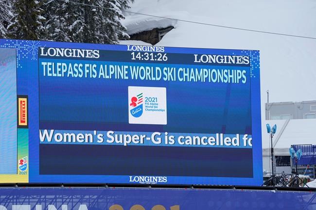 A giant screen in the finish area reports that the women's super-G was cancelled due to fog, at the alpine ski World Championships in Cortina d'Ampezzo, Italy, Tuesday, Feb. 9, 2021. (AP Photo/Giovanni Auletta)