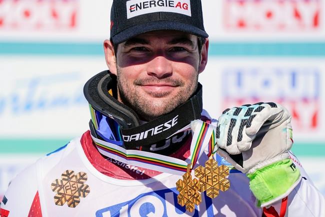 Austria's Vincent Kriechmayr poses with the gold medals of the men's downhill and super-G, at the alpine ski World Championships in Cortina d'Ampezzo, Italy, Sunday, Feb.14, 2021. (AP Photo/Giovanni Auletta)