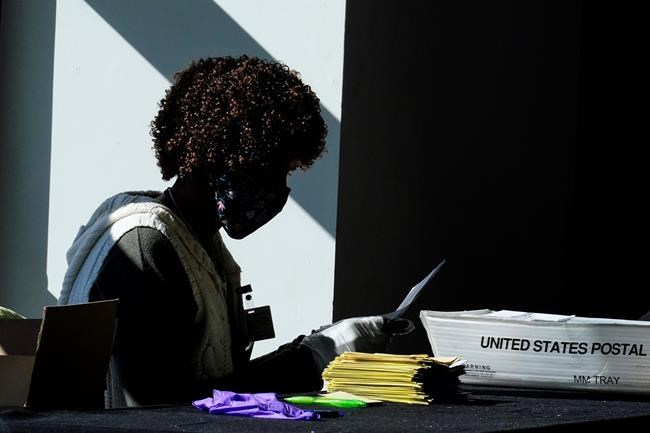 An election worker counts ballots at State Farm Arena on Wednesday, Nov. 4, 2020, in Atlanta. (AP Photo/Brynn Anderson)