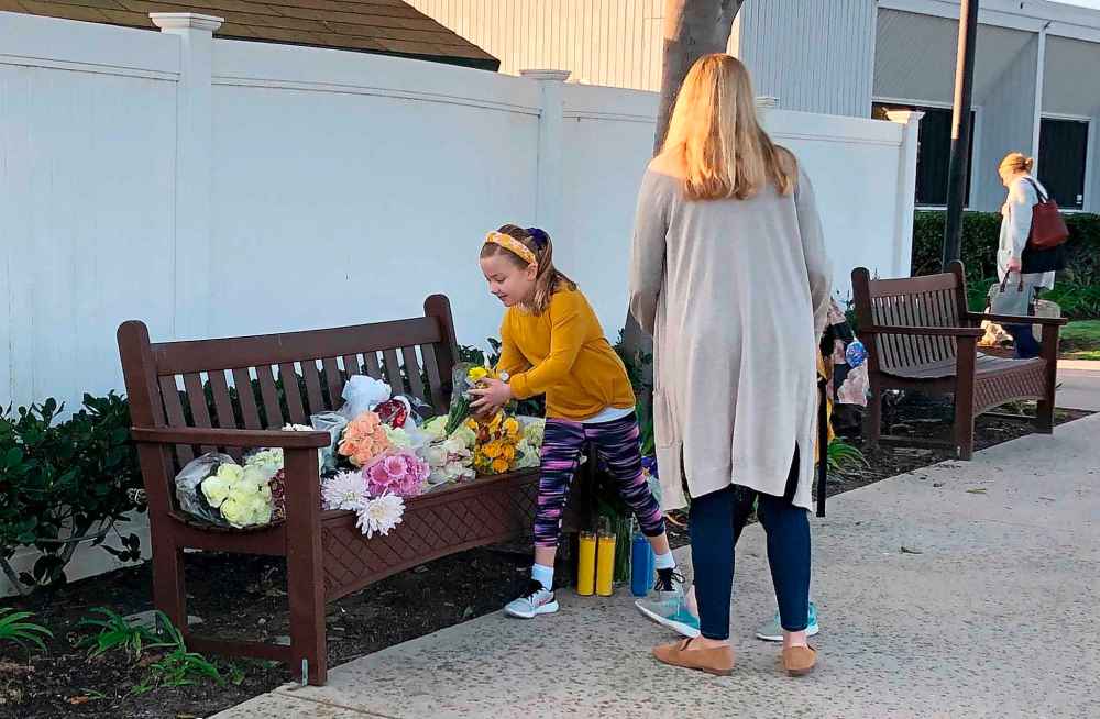 Flowers and messages are placed in front of Harbor Day School in Corona Del Mar, Calif., to pay tribute to Christina Mauser, a girls basketball coach at the school. (Amy Taxin / The Associated Press files)