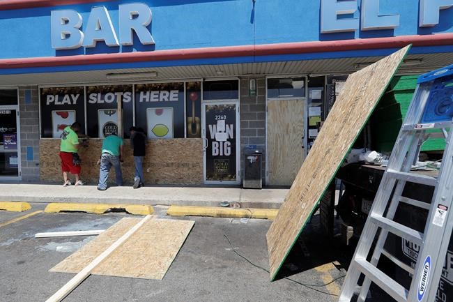 Workers board up windows at a store Tuesday, June 2, 2020, in Chicago. Chicago's Cicero neighborhood was vandalized last Monday in protests over the death of George Lloyd, a black man who died while in police custody on May 25. (AP Photo/Nam Y. Huh)