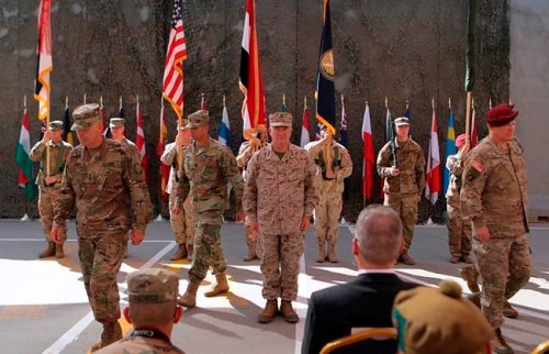 FILE - In this Sept. 14, 2019 file photo, U.S. Army Lt. Gen. Pat White, III Armored Corps Commanding General, second left, and Commanding General for U.S. Central Command Gen. Kenneth F. McKenzie Jr. center, take part in a transfer of authority ceremony at Union III, base in Baghdad, Iraq. On Sunday, Jan. 5, 2020, Iraq's parliament voted in favor of a resolution that calls for ending foreign military presence in the country two days after an Iranian general and a top commander were killed in a U.S. airstrike. The resolution specifically calls for ending an agreement in which Washington sent troops to Iraq more than four years ago to help in the fight against the Islamic State group. (AP Photo/Khalid Mohammed, File)