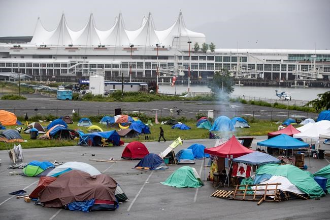 A man walks through a homeless camp where approximately 150 people are living at a parking lot on Port of Vancouver property adjacent to Crab Park, in Vancouver on June 10, 2020. A new report on women's homelessness in Canada reveals the number of women experiencing homelessness in Canada is dramatically underestimated. The study, led by the Women's National Housing & Homelessness Network, has found homelessness among women, especially for vulnerable populations, is made invisible by how it is defined, measured and how societies respond to housing needs. The federal government has provided funding to women's shelters as part of its response to the COVID-19 pandemic, but the report calls on Canada to take a more gender-sensitive approach to homelessness to stop large numbers of women from returning to violent and precarious situations. THE CANADIAN PRESS/Darryl Dyck