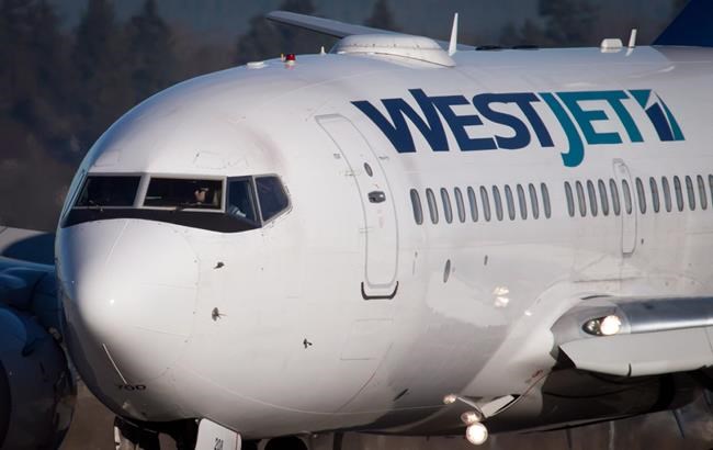 A pilot taxis a Westjet Boeing 737-700 plane to a gate after arriving at Vancouver International Airport in Richmond, B.C., on February 3, 2014. WestJet Airlines Ltd. says it has asked the federal labour minister for an exemption to Canada Labour Code provisions covering group terminations. The company said in an email the exemption would give it flexibility