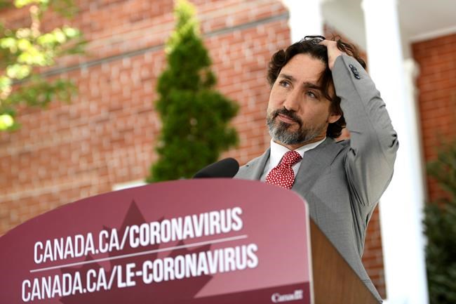 Prime Minister Justin Trudeau brushes his hair out of his eyes as he listens to a question during his daily news conference on the COVID-19 pandemic outside his residence at Rideau Cottage in Ottawa, on Wednesday, May 20, 2020. THE CANADIAN PRESS/Justin Tang