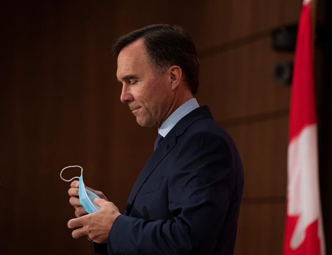 Minister of Finance Bill Morneau removes his mask as he prepares to announce his resignation during a news conference on Parliament Hill in Ottawa, on Monday, Aug. 17, 2020. THE CANADIAN PRESS/Justin Tang