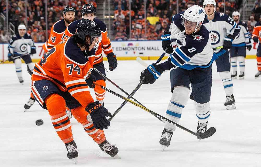 THE CANADIAN PRESS/Jason Franson
Winnipeg Jets' Andrew Copp takes a shot as Edmonton Oilers' Ethan Bear tries to block it during the first period in Edmonton on Wednesday.