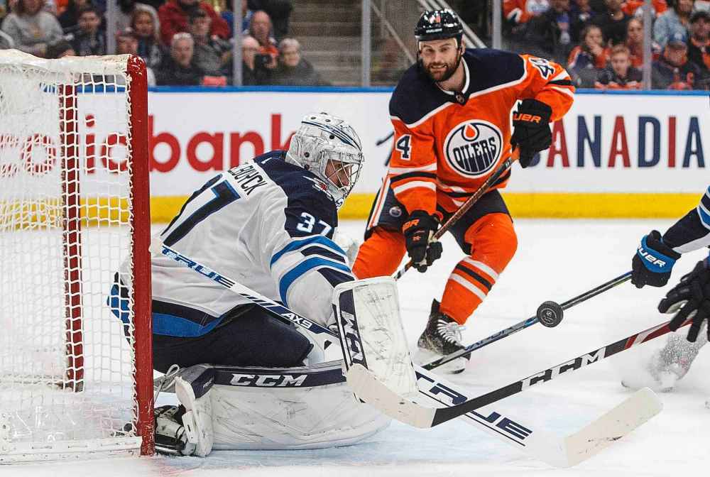 THE CANADIAN PRESS/Jason Franson
Jets goalie Connor Hellebuyck makes a save as Edmonton Oilers' Zack Kassian looks for the rebound during the second period.