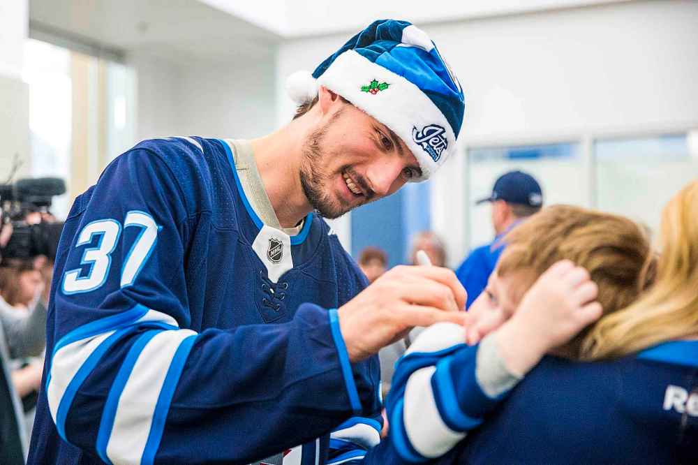 MIKAELA MACKENZIE / WINNIPEG FREE PRESS
Jets goalie Connor Hellebuyck signs jerseys.