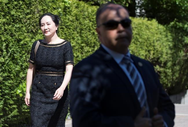 A security guard looks on as Meng Wanzhou, chief financial officer of Huawei, leaves her home to go to B.C. Supreme Court in Vancouver, Wednesday, May 27, 2020. The federal government is trying to block Huawei executive Meng Wanzhou's access to some documents in her extradition case, arguing in court documents that disclosing sensitive information would harm national security. THE CANADIAN PRESS/Jonathan Hayward