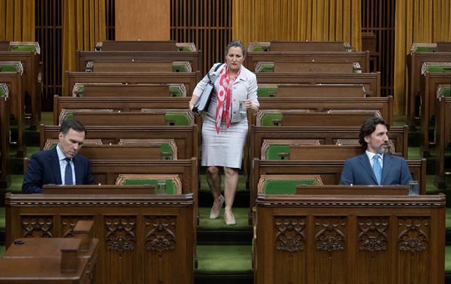 Deputy Prime Minister and Minister of Intergovernmental Affairs Chrystia Freeland looks for a seat as Minister of Finance Bill Morneaua and Prime Minister Justin Trudeau wait for a session of the Special Committee on the COVID-19 Pandemic to begin in the Chamber of the House of Commons in Ottawa, Wednesday May 13, 2020. THE CANADIAN PRESS/Adrian Wyld