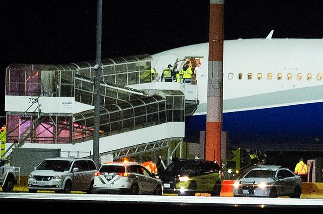 Jonathan Hayward / THE CANADIAN PRESS
Officials gather at the entrance of a plane carrying Canadians back from Wuhan, China, on the tarmac at Vancouver International Airport, in Richmond, B.C., Thursday, Feb. 6, 2020. THE CANADIAN PRESS/Jonathan Hayward