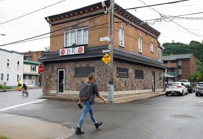 A man walks by the Bar Kirouac, which was closed after people were infected with COVID-19 while participating in karaoke earlier in the week, Wednesday, September 2, 2020 in Quebec City. THE CANADIAN PRESS/Jacques Boissinot