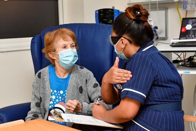Nurse May Parsons prepares 90 year old Margaret Keenan, the first patient in the UK to receive the Pfizer-BioNTech COVID-19 vaccine, at University Hospital, Coventry, England, Tuesday Dec. 8, 2020. The United Kingdom, one of the countries hardest hit by the coronavirus, is beginning its vaccination campaign, a key step toward eventually ending the pandemic. (Jacob King/Pool via AP)