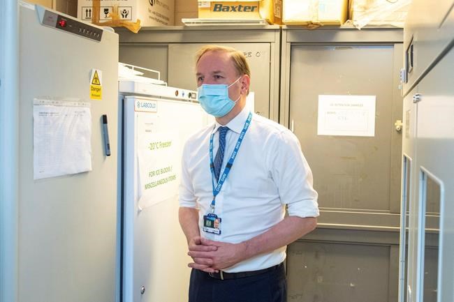 Sir Simon Stevens, the Chief Executive of the National Health Service in England, looks at the freezer facility at the Royal Free Hospital in London, Monday Dec. 7, 2020, during a visit to see preparations and meet staff who will be starting the coronavirus vaccination programme from Tuesday. (Dominic Lipinski/Pool via AP)