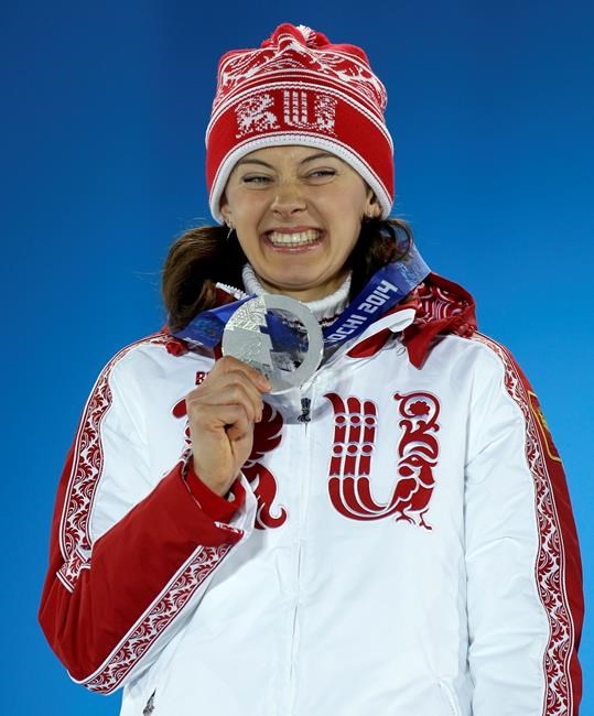 FILE - In this Monday, Feb. 10, 2014 file photo, women's 7.5K sprint silver medalist Olga Vilukhina of Russia smiles with her medal during the medals ceremony at the 2014 Winter Olympics, in Sochi, Russia. Two-time Olympic biathlon champion Olga Zaitseva lost her appeal Thursday Sept. 24, 2020, against disqualification from the 2014 Sochi Olympics for her part in Russia’s state-backed doping program and two of Zaitseva’s relay teammates at Sochi, Olga Vilukhina and Yana Romanova, won their appeals and had their IOC disqualifications from individual biathlon events at Sochi overturned. (AP Photo/Morry Gash, File)