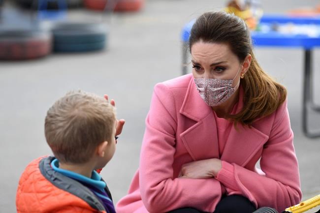 Britain's Kate, Duchess of Cambridge watches as a child holds up five fingers to indicate his age during a visit with Prince William to School21, a school in east London, Thursday March 11, 2021. (Justin Tallis/Pool via AP)