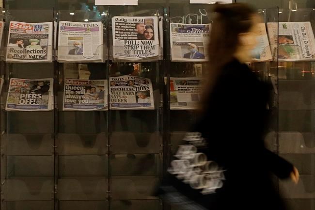 A pedestrian passes newspapers on display with front pages featuring images of members of the royal family, outside a shop in London, Wednesday, March 10, 2021. In countries with historic ties to Britain, allegations by Prince Harry and Meghan about racism within the royal family have raised questions about whether those nations want to be closely connected to Britain anymore after the couple's interview with Oprah Winfrey. (AP Photo/Kirsty Wigglesworth)