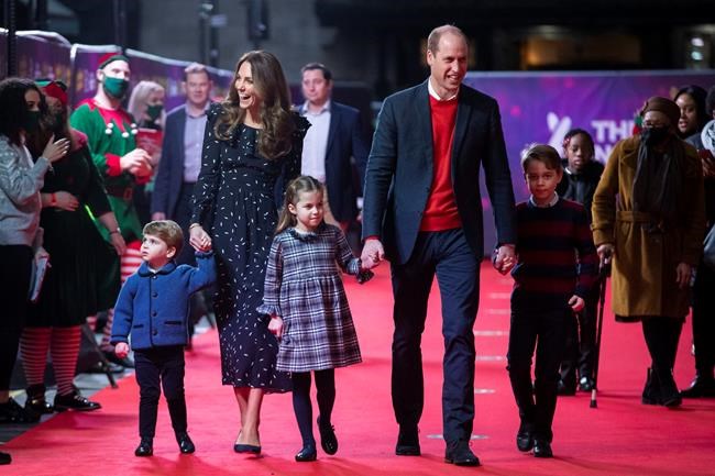 FILE - In this Friday Dec. 11, 2020 file photo, Britain's Prince William and Kate, The Duke and Duchess of Cambridge and their children, Prince Louis, left, Princess Charlotte and Prince George arrive for a special pantomime performance at London's Palladium Theatre. One of the most dramatic claims in Prince Harry and Meghan's interview with Oprah Winfrey was that their son was denied a royal title, possibly because of the color of his skin. Queen Elizabeth II has nine great-grandchildren, including Archie. They are not princes and princesses, apart from the three children of Prince William, who is second in line to the throne and destined to be king one day. (Aaron Chown/Pool via AP, file)