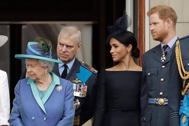 FILE - In this Tuesday, July 10, 2018 file photo Britain's Queen Elizabeth II, Prince Andrew, Meghan the Duchess of Sussex and Prince Harry stand on a balcony to watch a flypast of Royal Air Force aircraft pass over Buckingham Palace in London. As part of a surprise announcement distancing themselves from the British royal family, Prince Harry and his wife Meghan declared they will