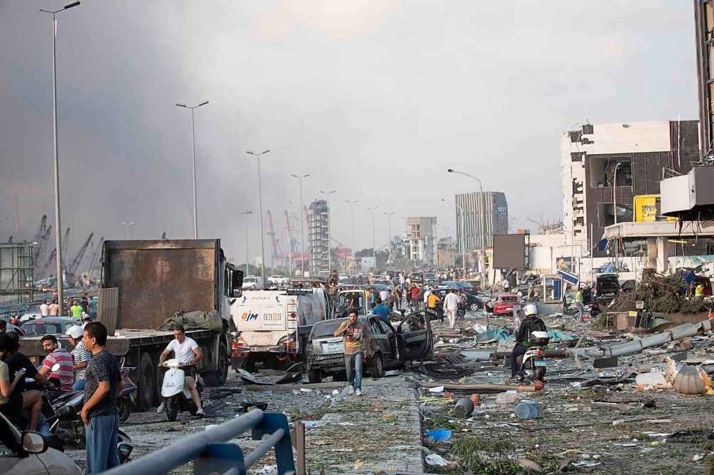 People evacuate wounded individuals after of a massive explosion in Beirut, Lebanon, Tuesday, Aug. 4, 2020. Witnesses saw many people injured by flying glass and debris. (AP Photo/Hassan Ammar)