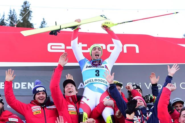 First placed Switzerland's Daniel Yule, top center, celebrates with teammates at the end of an alpine ski, World Cup Men's slalom in Adelboden, Switzerland, Sunday, Jan. 12, 2020. (AP Photo/Marco Tacca)