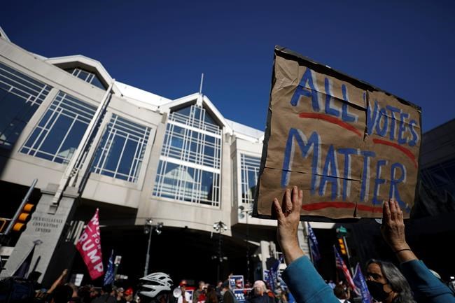 People demonstrate outside the Pennsylvania Convention Center where votes are being counted, Friday, Nov. 6, 2020, in Philadelphia. (AP Photo/Rebecca Blackwell)