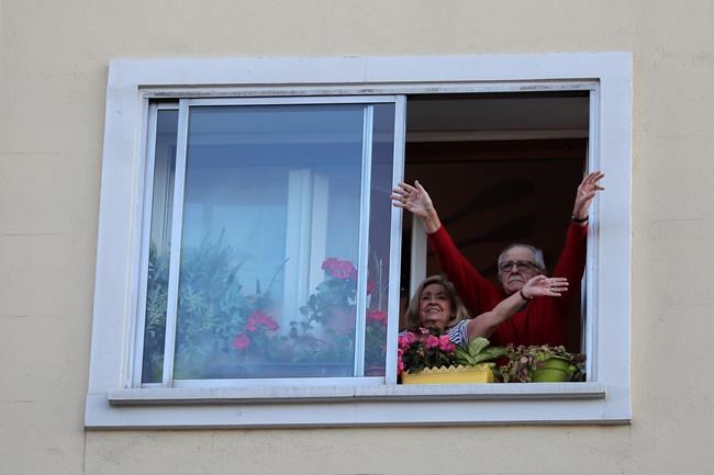 People applaud from their houses in support of the medical staff that are working on the COVID-19 virus outbreak at the Gregorio Maranon hospital in Madrid, Spain, Wednesday, April 1, 2020. The new coronavirus causes mild or moderate symptoms for most people, but for some, especially older adults and people with existing health problems, it can cause more severe illness or death. (AP Photo/Manu Fernandez)