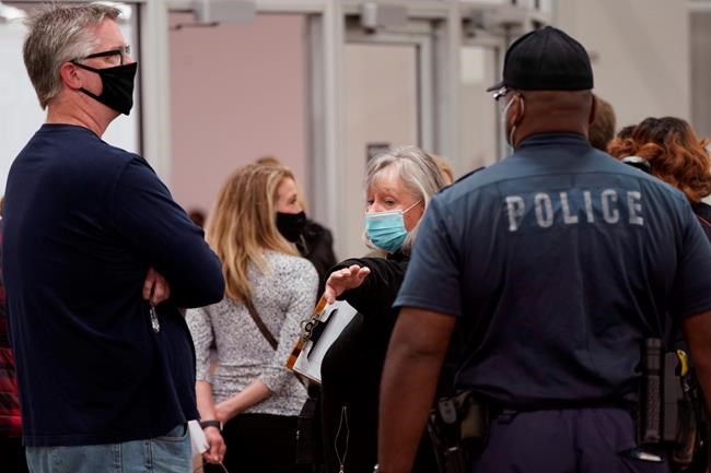 A Detroit police officer stops election challengers from entering the central counting board due to overcrowding, Wednesday, Nov. 4, 2020, in Detroit. (AP Photo/Carlos Osorio)