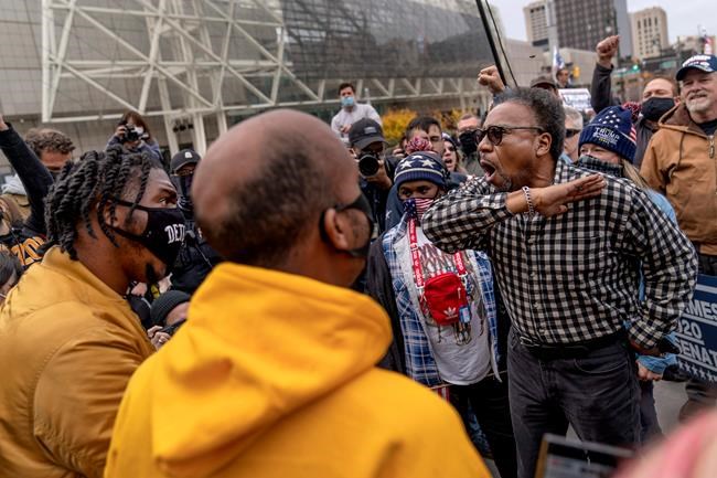 Trump supporter C.L. Bryant, right, argues with counter protestors Angelo Austin, left, and Ralph Gaines, center, while Trump supporters demonstrate against the election results outside the central counting board at the tcf Center in Detroit, Thursday, Nov. 5, 2020. (AP Photo/David Goldman)