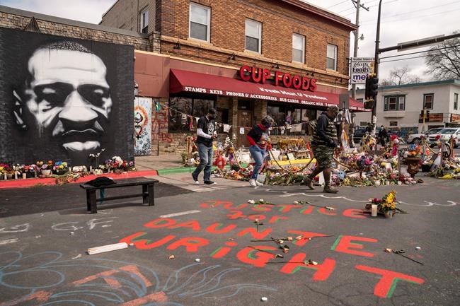 Visitors browse a memorial to George Floyd as a new addition commemorating Daunte Wright is displayed outside Cup Foods, Wednesday, April 14, 2021, in Minneapolis, Minn. (AP Photo/John Minchillo)