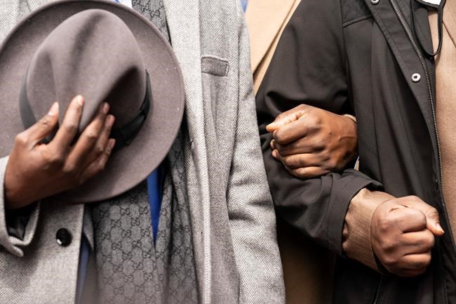 Philonise Floyd, left, and Rodney Floyd, right, brothers of George Floyd, lock arms during a prayer alongside attorney Ben Crump, left, during a news conference outside the Hennepin County Government Center before the murder trial against former Minneapolis police officer Derek Chauvin in the killing of George Floyd advances to jury deliberations, Monday, April 19, 2021, in Minneapolis. (AP Photo/John Minchillo)