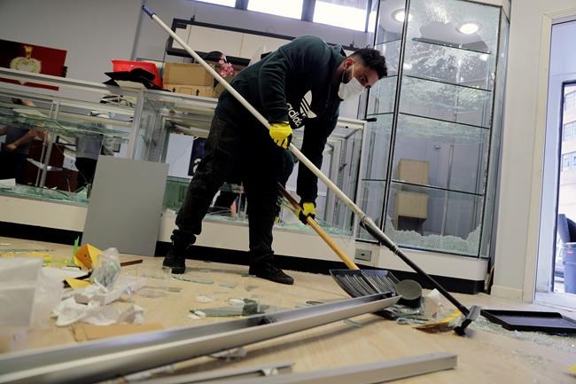 Syed Sajid cleans up inside his store, Gold & Diamonds, Tuesday, June 2, 2020, in St. Louis. The shop, like several other in downtown St. Louis, was burglarized and ransacked on Monday night well after peaceful protesters gathered in the afternoon to speak out against the death of George Floyd who died after being restrained by Minneapolis police officers on May 25. (AP Photo/Jeff Roberson)