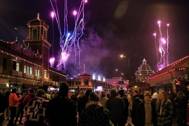 A crowd watches building lights come on as fireworks light up the sky during the Plaza Lighting Ceremony in Kansas City, Mo., Thursday, Nov. 28, 2019. The Country Club Plaza is a famous shopping district in Kansas City. This is the 90th year of the Plaza lights. (AP Photo/Orlin Wagner)