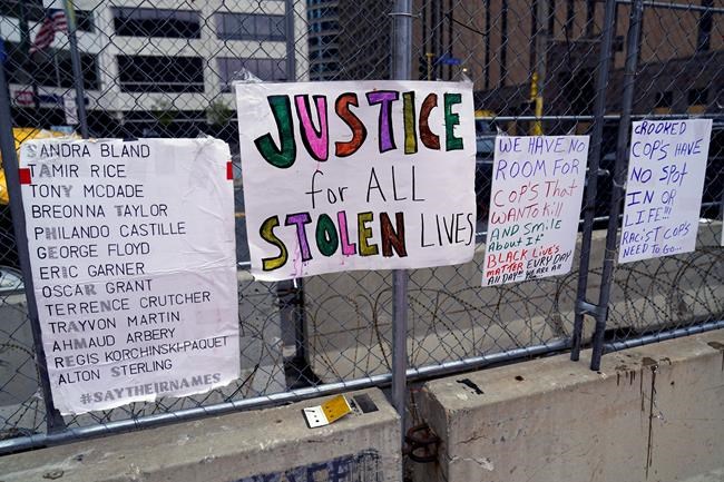 New signs are on a fence at the Hennepin County Government Center, Monday, April 19, 2021, in Minneapolis where closing arguments are being heard in the trial of former Minneapolis police officer Derek Chauvin continues. Chauvin is charged with murder in the death of George Floyd during an arrest last may in Minneapolis. (AP Photo/Jim Mone)