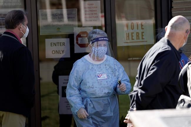 Poll worker Dina Grinstead assists voters at the Graham Civic Center polling location in Graham, N.C., Tuesday, Nov. 3, 2020. (AP Photo/Gerry Broome)