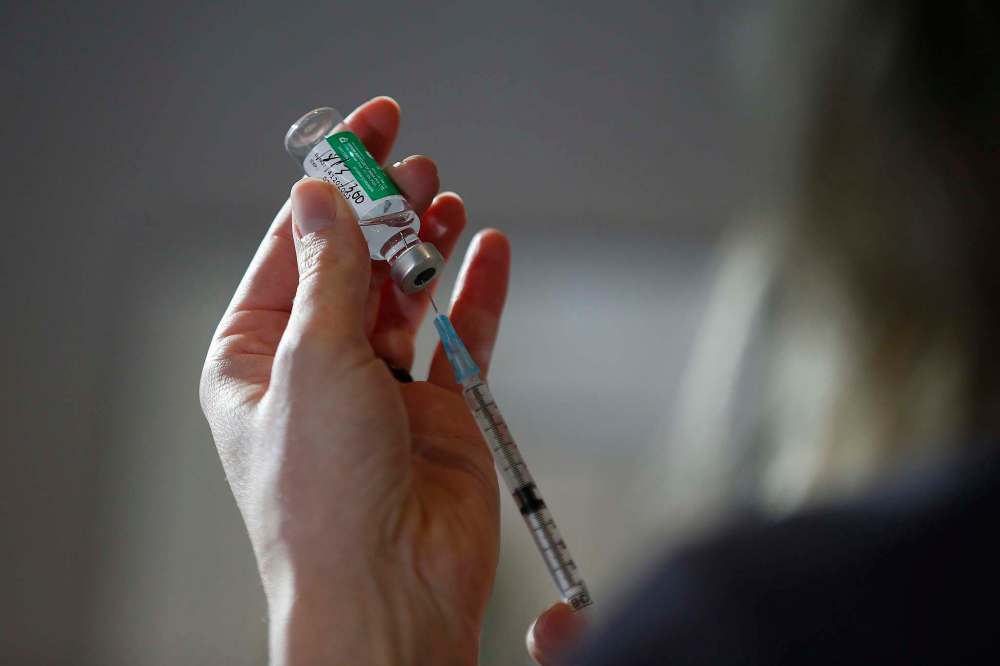 Dr. Joss Reimer, medical lead, Manitoba Vaccine Implementation Task Force draws a dose of the AstraZeneca COVID-19 vaccine at a clinic in Winnipeg, Friday, March 19, 2021. THE CANADIAN PRESS/John Woods